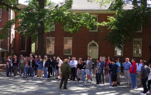 Color photo of a park service ranger speaking to tourists before they begin the Independence Hall tour. 