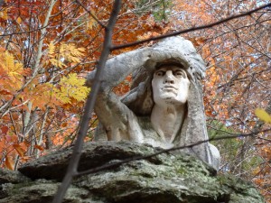 color photo of Lenape chieftan's face with right arm raised to shade eyes while scouting the distance. topmost part of statue in Wissahickon Valley Park.