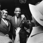 a black and white photograph of Wilson Goode smiling in a crowd