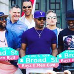 Photograph of Boyz II Men holding street signs