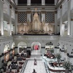 A photograph of the interior court of the former Wanamaker's store on Market Street, featuring the Grand Organ acquired from the St. Louis World's Fair of 1904.
