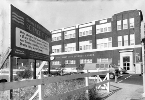 A black and white photograph of the a three story building with the words 