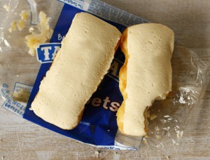 A photograph of two butterscotch krimpets, unwrapped and set in their wrapper