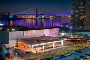 A view of the SugarHouse Casino at night with the Ben Franklin Bridge in the background.