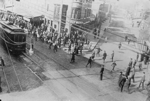 A group of strikers throw stones at a passing trolley car.