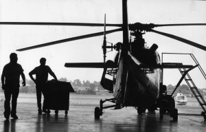 A black and white photograph of two people next to a helicopter near the northeast Philadelphia airport. 