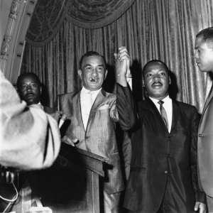 A black and white photo of NAACP leader Cecil B. Moore and Martin Luther King, Jr. holding hand together at a press conference