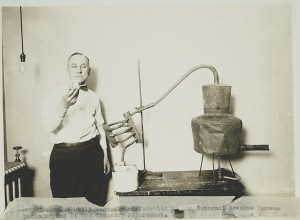 An Internal Revenue Service (IRS) agent scrutinizes the contents of a moonshine still during the Prohibition era.