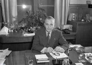 A black and white photograph of Richardson Dilworth seated at his desk