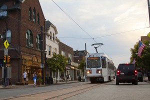 A color photograph of a streetcar passing by shops in Media, Pa.