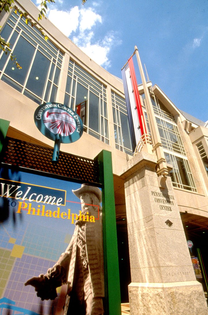 color photograph of the pennsylvania convention center, taken from the street directly below, looking up. A column elevates the building and the second floor