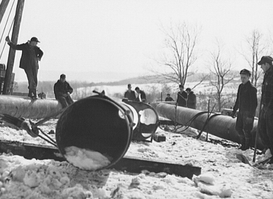 Workers with a portion of pipe for the War Emergency Pipeline.