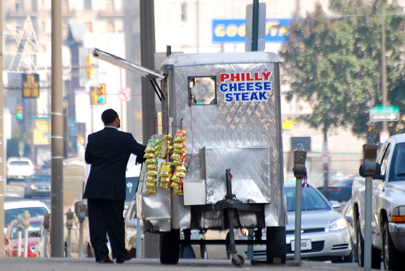 Man in suit awaiting lunch from a cheesesteak vendor on North Broad Street in 2008.