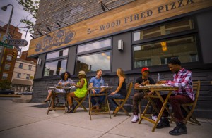 a color photo of patrons eating outside of the Bufad pizzeria