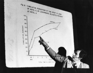 A black and white photograph of a man pointing to a graph about the Legionella outbreak