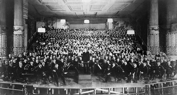 A black and white photograph of the Philadelphia Orchestra on stage at the Academy of Music