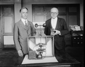 A black and white photo of Paul R. Heyl and Lyman James Briggs with their earth inductor compass and the magellanic premium award