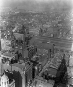 Black and white photograph overlooking Thirteenth Street with the Hotel Vendig in the foreground and the old Reading Terminal right center. The Delaware River is visible in the distance.