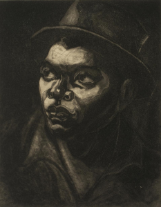 A dramatic portrait (carborundum print) of a man wearing a hat, looking upward and to the left, with light shining on his face from that direction. He wears a collared shirt and the background is pitch black, with light accents around the edges of his hat.