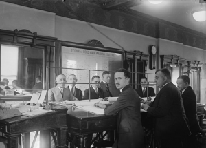 A black and white photograph of a group of meteorologists hand drawing weather maps