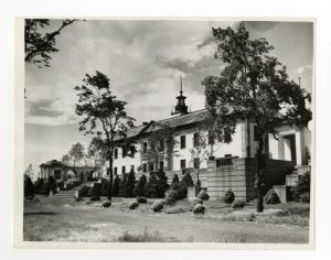 A black and white photograph of the American Swedish Historical Museum, a white, classically-inspired building with a green roof adorned with a columned edifice.