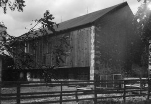 A black and white photograph of the exterior of a mid to late eighteenth century grain mill.