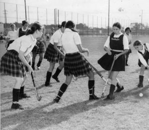 A black and white photograph of local high school girls playing field hockey.