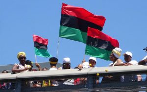 ODUNDE festival celebrants on the South Street Bridge on June 12, 2016, display Pan-African flags while throwing offerings into the Schuylkill River during the festival, which has its roots in Nigeria.