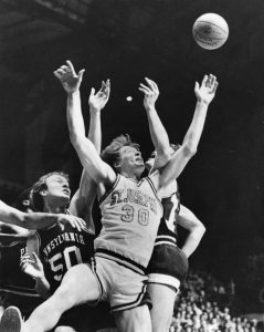 A Saint Joesph's University player battles two University of Penn players for a loose ball