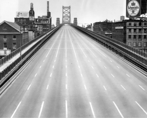 A black and white photograph of the road bed of Benjamin Franklin Bridge with no cars during an air raid drill