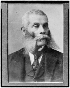 A black and white photograph of Alexander Kelly as an elder, head and shoulders, wearing a suit and tie