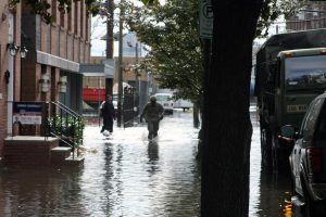 Color photograph of a National Guardsmen returning to an army truck on a flooded street in Hoboken, New Jersey.