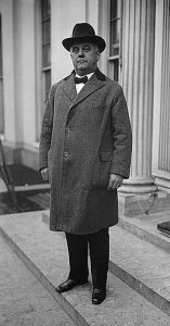 A black and white photograph of William S. Vare near the front door of a building.