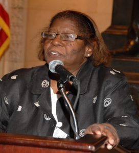 color photograph of Lurline Jones standing at lectern with microphone