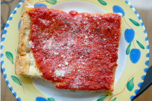 a color photograph of a rectangular slice of tomato pie on a blue and yellow plate