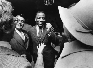 a black and white photograph of Wilson Goode smiling in a crowd