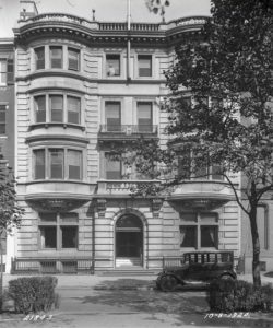 a black and white photograph of the Rittenhouse Club Headquarters, a four story building with a flat roof, white limestone facade, and twin bay windows