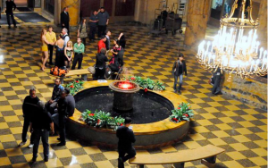 a color photograph of a group of actors gathered in the lobby of the Benjamin Franklin House.