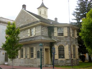 a color photograph of a two story Colonial building clad in stone.