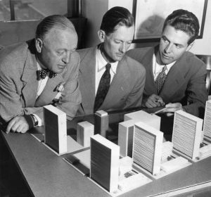 A black and white photograph of Earle Barber, Edmund Bacon, and Vincent Kling looking over a model of Penn Center.