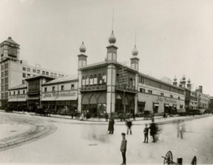 a black and white photograph of a former rail station converted into a department store. 