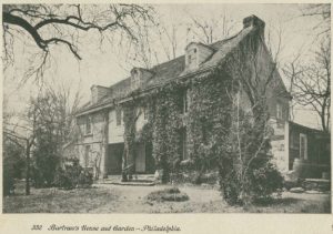 Scan of a postcard that shows, in black and white, the home of John Bartram. The home is a large, three story structure surrounded by ample grounds and many trees.