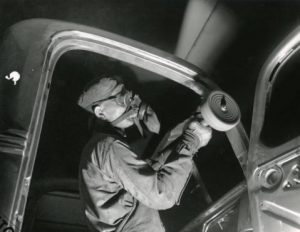 A Budd Company employee tends the steel frame of an automobile bodt in 1939.