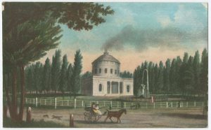 a color illustration of the Centre Square water works. The building is modeled after a Greek temple and surrounded on either side by a row of trees. A large fountain in front of the building gives off jets of water. In the foreground, a horse carriage and a dog traverse a road.