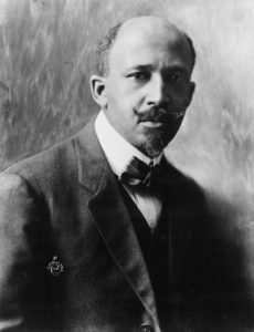 A black and white photograph of W.E.B. DuBois at around ate 50. He wears a dark suit and bow tie.