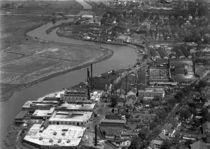 Black and white aerial photograph showing large industrial complex owned by the Heinz corporation along the right bank of the Salem River as well as homes and other buildings.