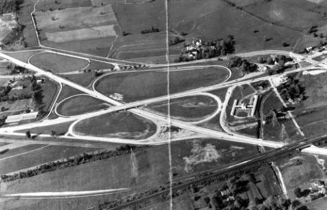 a black and white aerial photograph of a cloverleaf highway interchange in King of Prussia