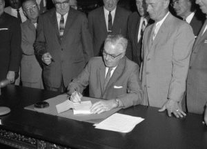 A black and white photograph of Mayor Tate signing the new zoning code for Philadelphia.