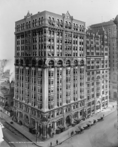 A black and white photograph of the Betz Building, a fourteen story stone building standing on the corner of Center Square.