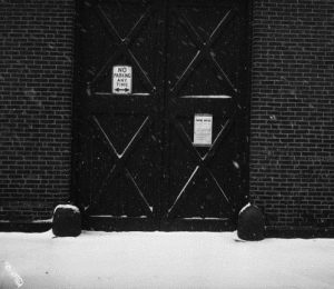 A black and white photograph of a building with a zoning notice to become a branch of Philadelphia's public library.